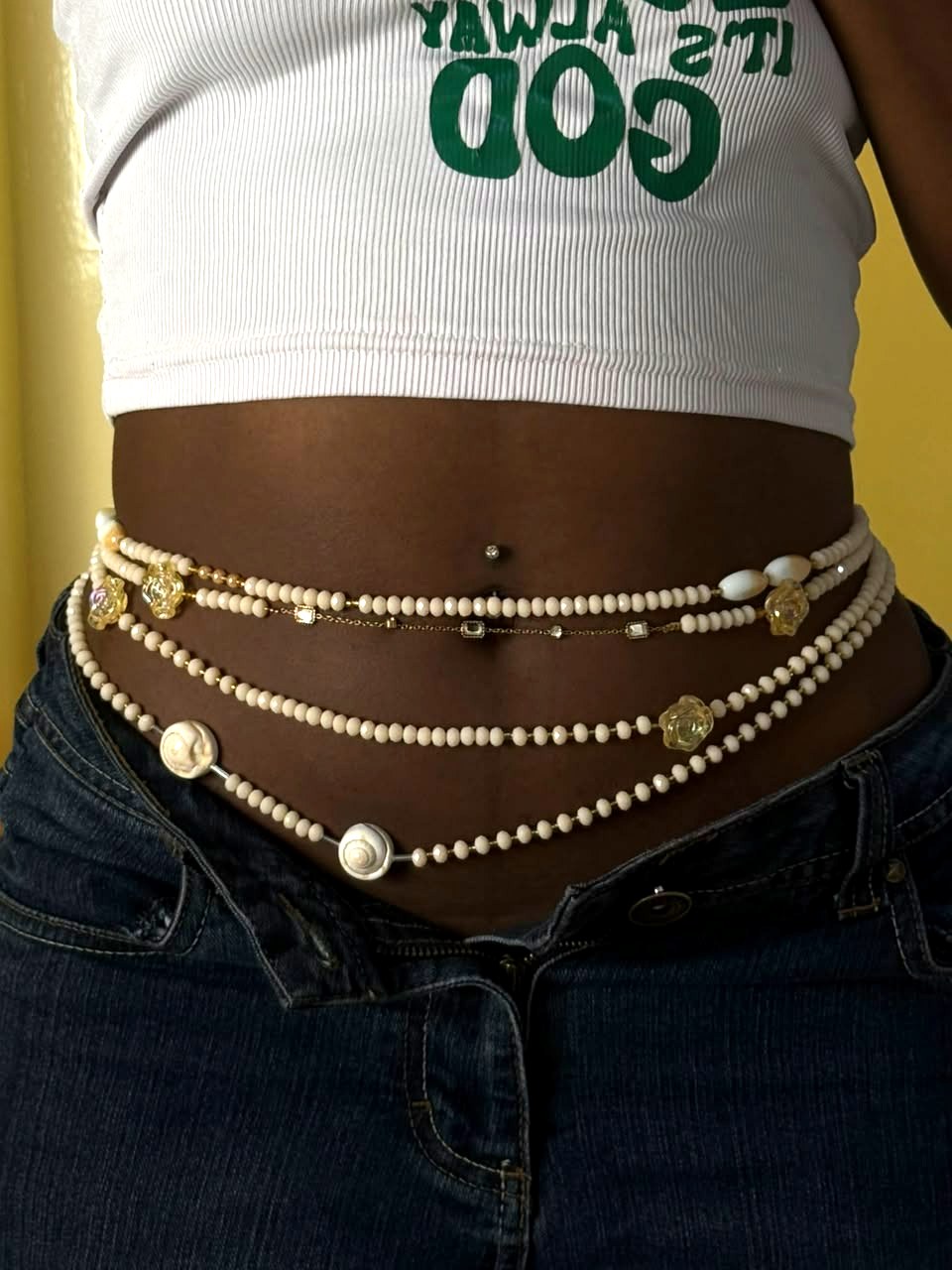 Chaîne de ventre Éclat Ivoire en perles ivoire, nacre blanche et fleurs translucides, portée sur les hanches